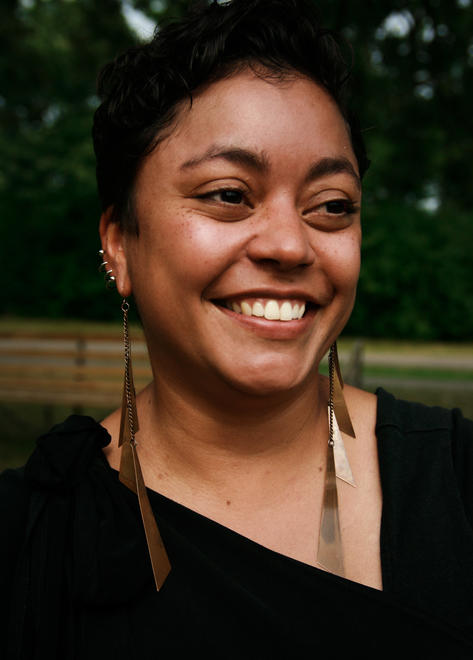 Hadija Steen-Mills, a smiling mixed-Black person.