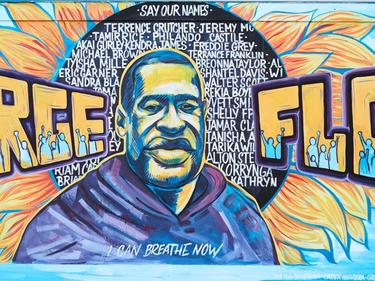 Mural of George Floyd with joyful, dynamic gold and blue colors.
